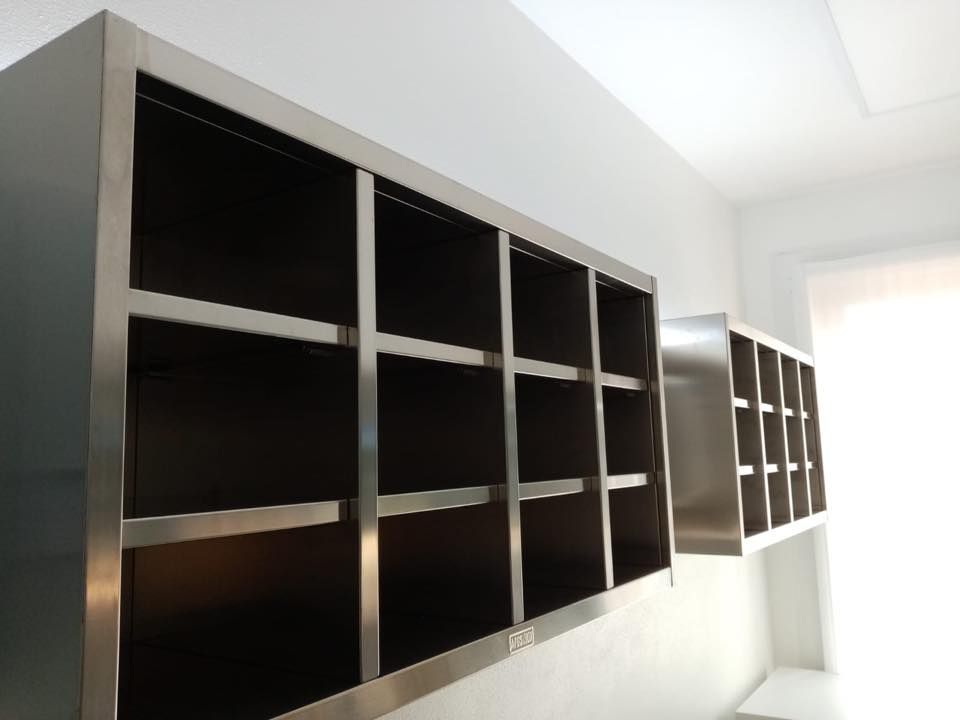 Una fila di ripiani in acciaio inossidabile contro una parete bianca