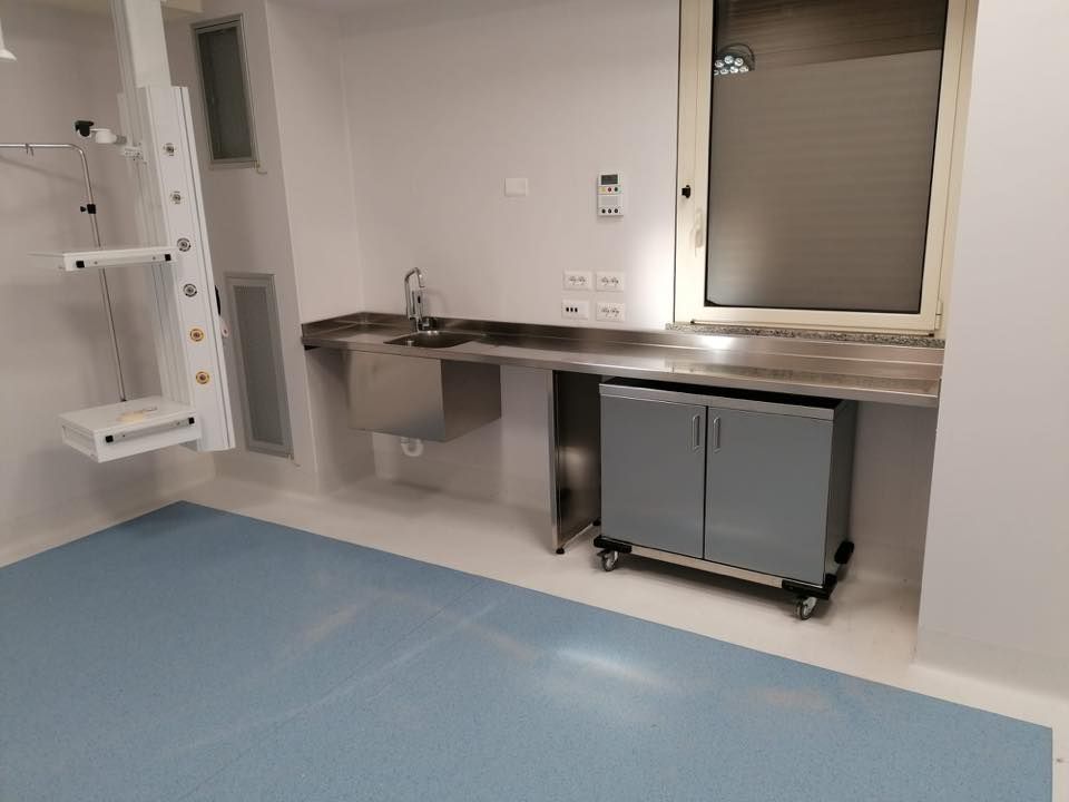 Una stanza con un lavandino, degli armadietti e una finestra.