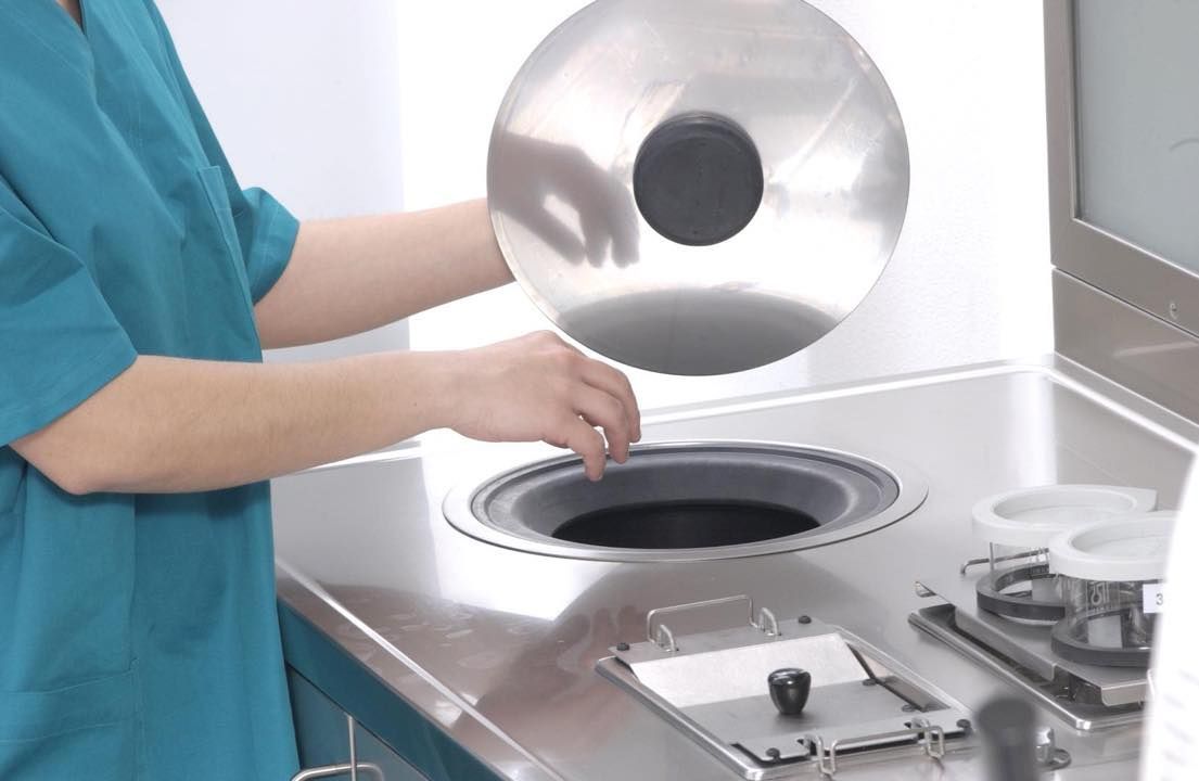 Una persona sta mettendo un coperchio su un contenitore di acciaio inossidabile.