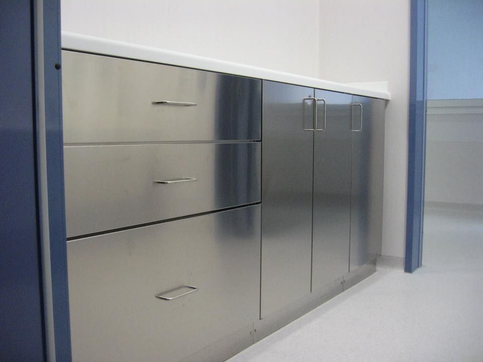 Una cucina con mobili e cassetti in acciaio inox