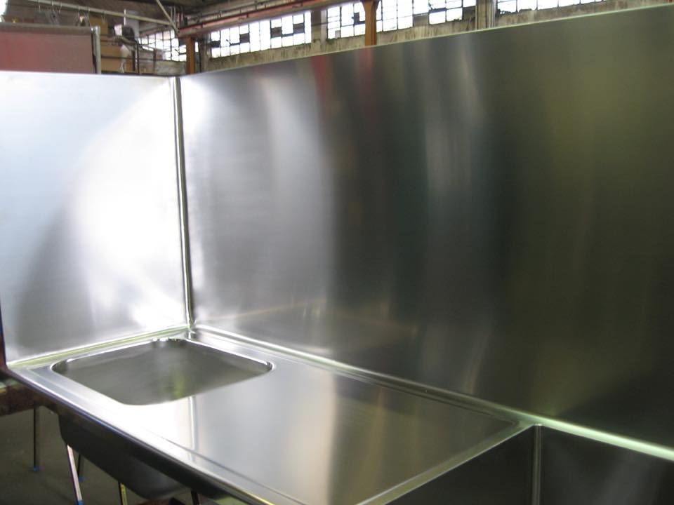 Un bancone da cucina in acciaio inossidabile con un lavandino al suo interno