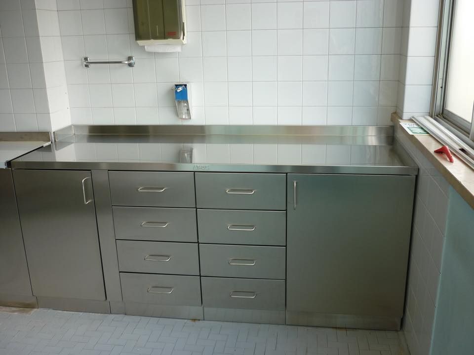 Una cucina con mobili e cassetti in acciaio inox