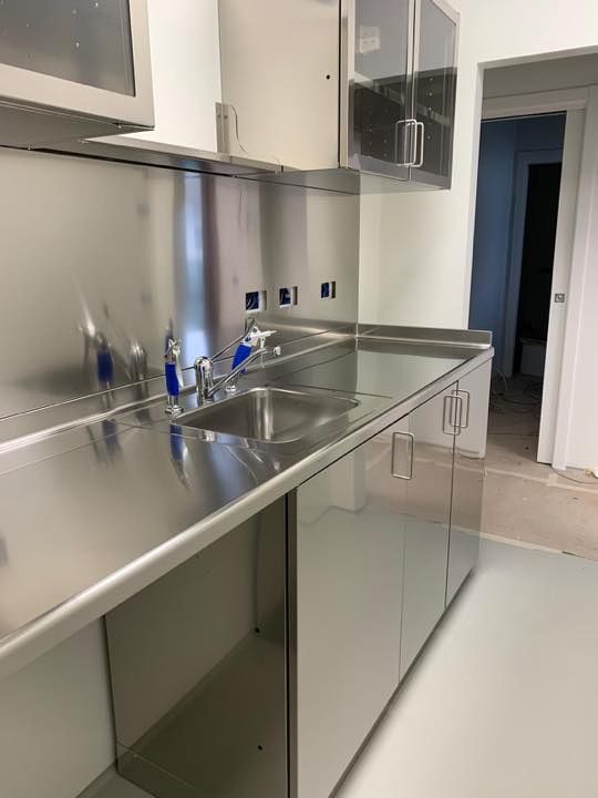 Una cucina con mobili in acciaio inox e un lavello.