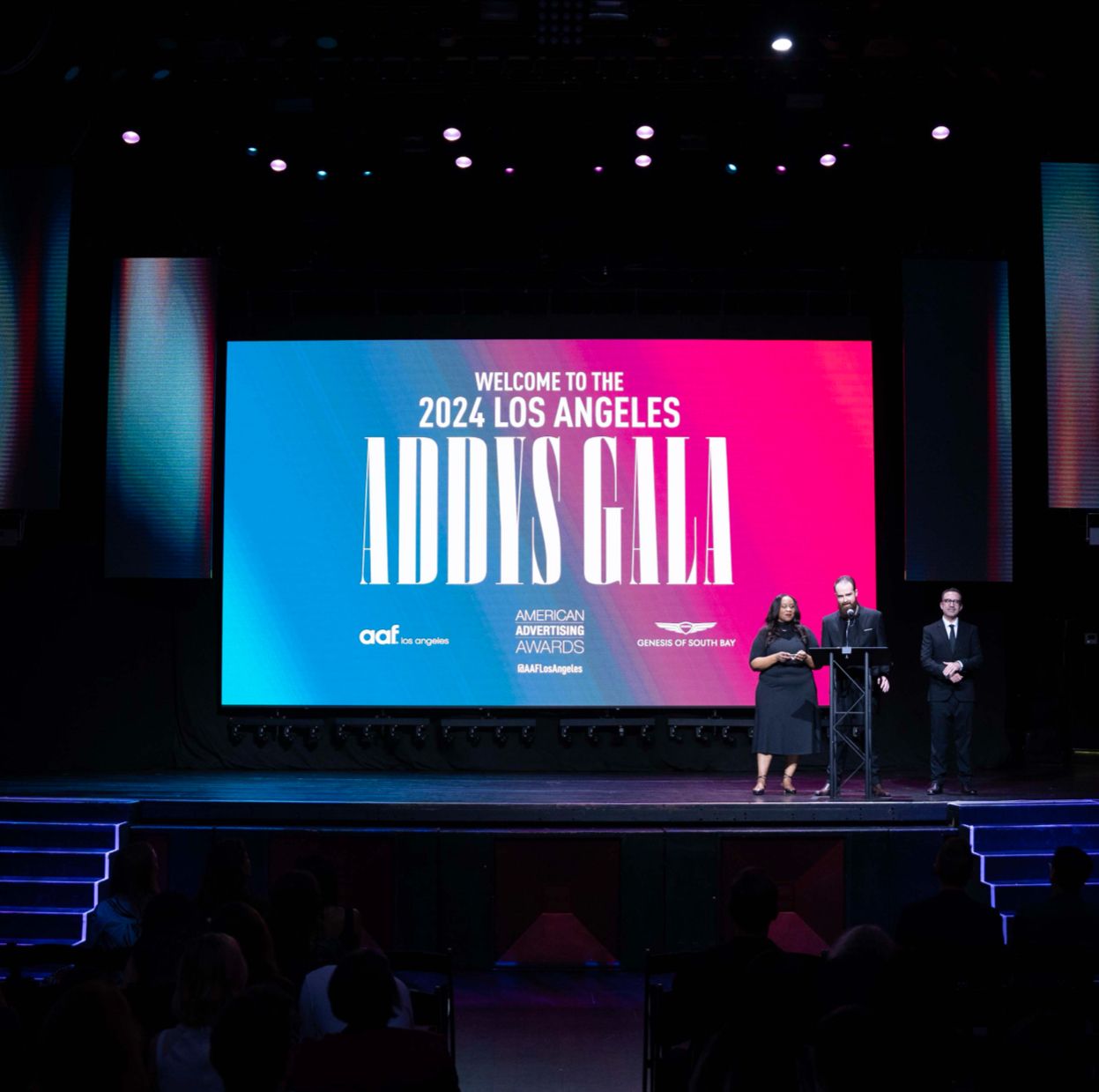 3 people standing on a stage, from left to right: Erica Coates, Chris Degenaars, Raul Rios at the 2024 Los Angeles ADDYS Gala