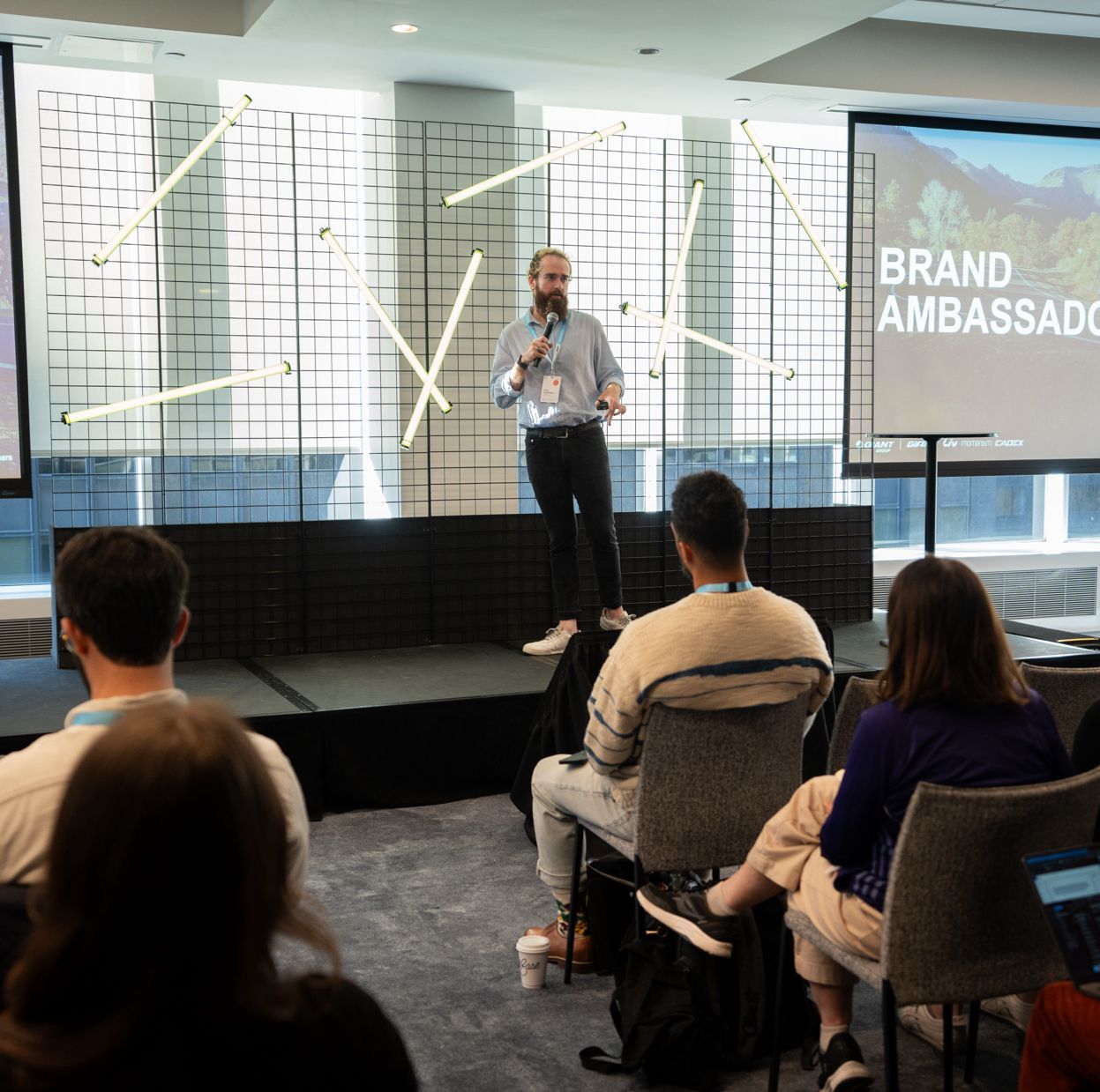 A photo of Chris Degenaars standing in front of a room speaking.