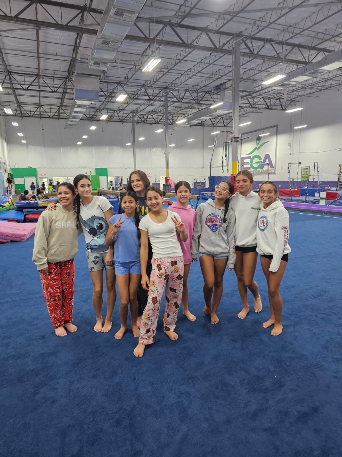 Un grupo de chicas jóvenes posan para una foto en un gimnasio.