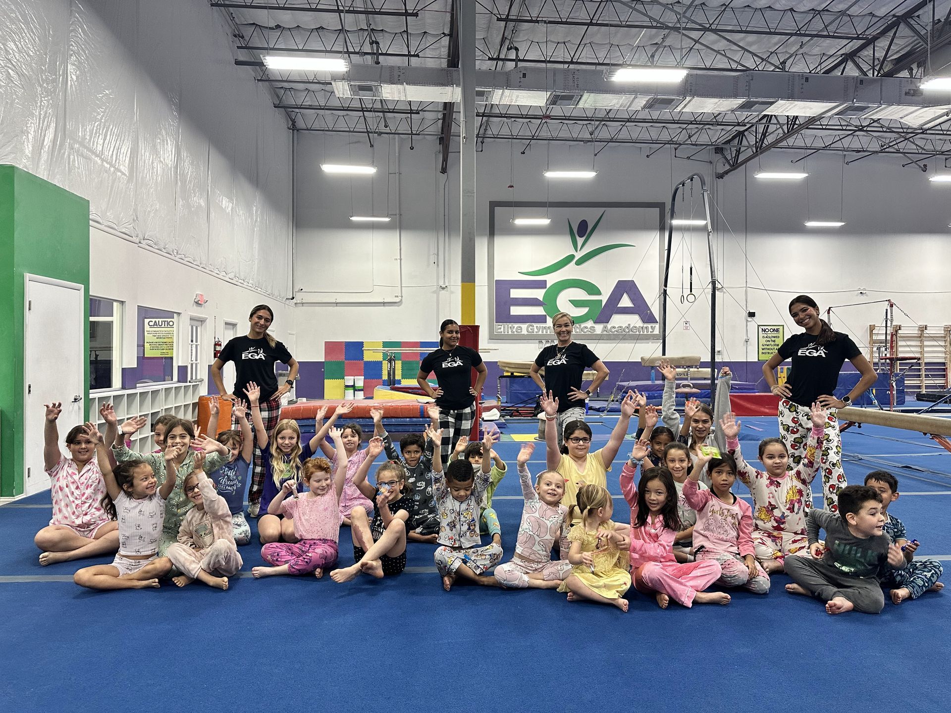 Un grupo de niños posa para una fotografía en un gimnasio.