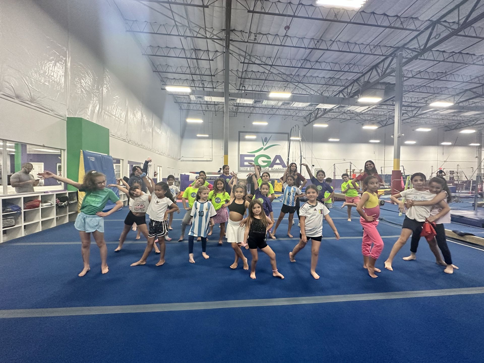 Un grupo de chicas jóvenes están bailando en un gimnasio.