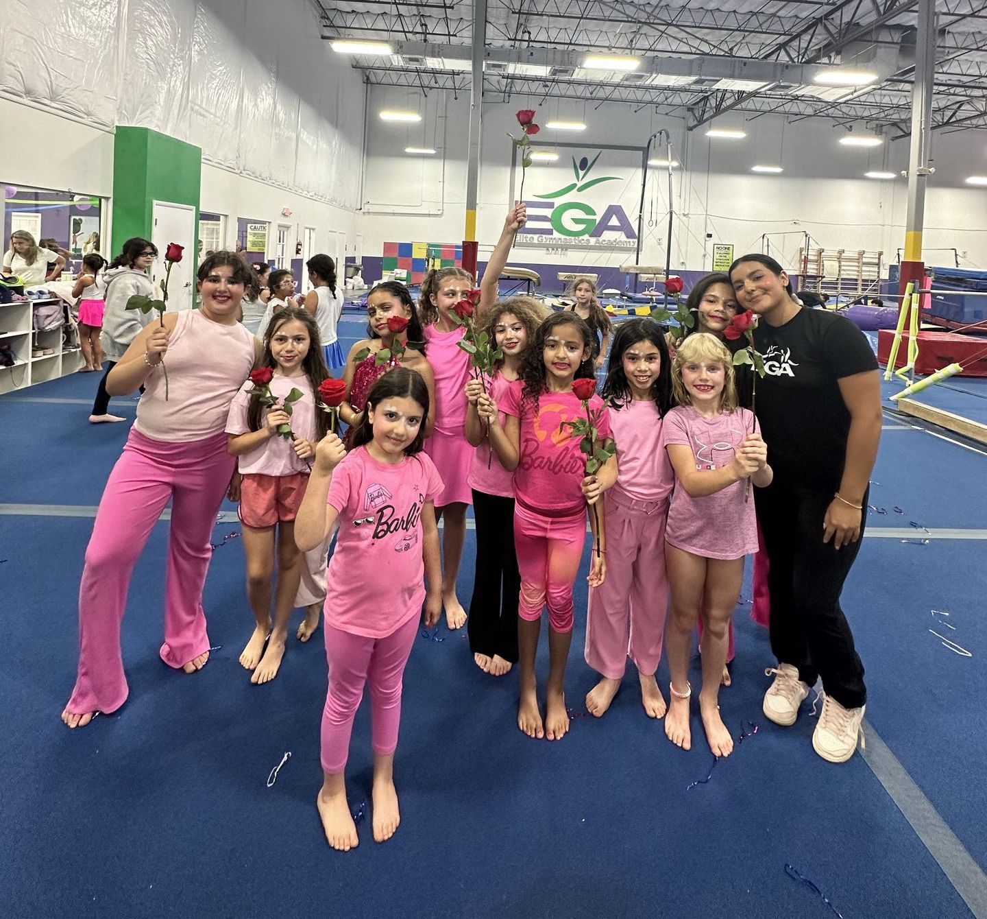 Un grupo de chicas jóvenes posan para una foto en un gimnasio.
