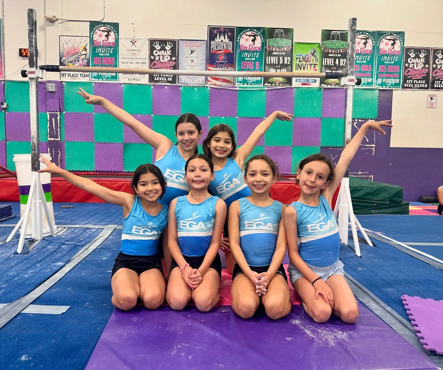 Un grupo de chicas jóvenes posan para una foto en un gimnasio.