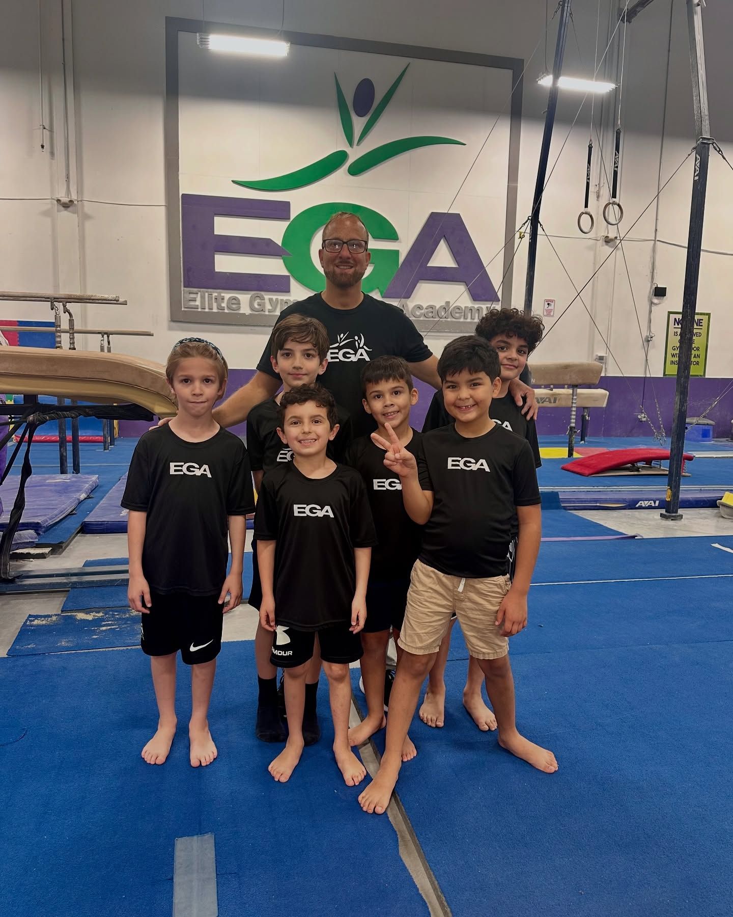 Un grupo de chicos jóvenes posan para una foto en un gimnasio.