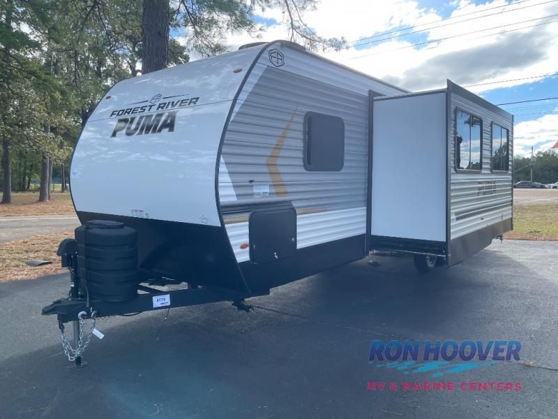 A Forest River Puma travel trailer with a slide-out, parked outdoors.