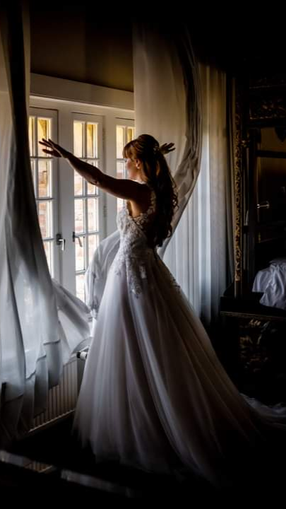 Bruid met opgestoken lang haar net voor  de first look