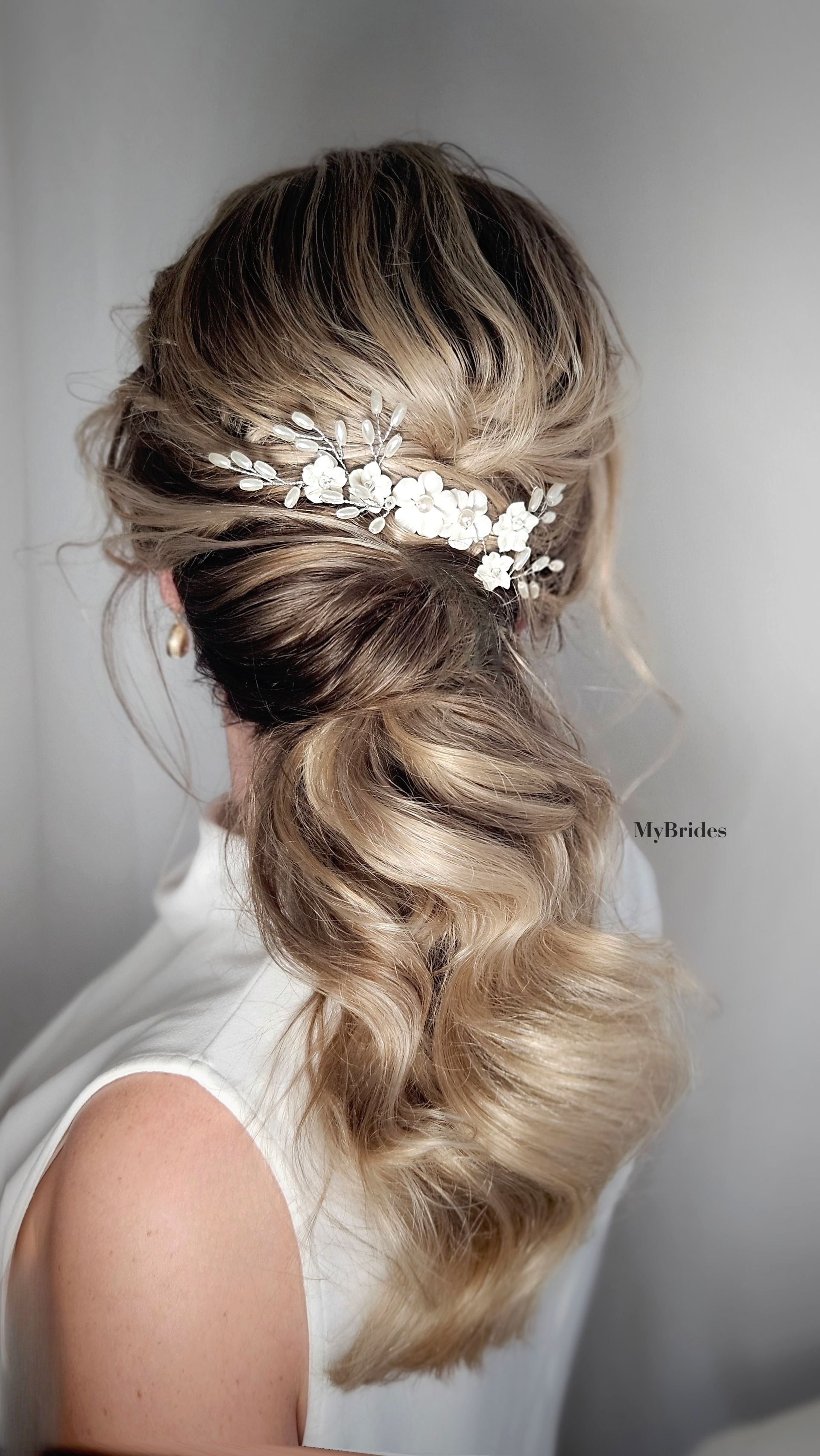 Een lage staart met bruidsaccessoires voor een klassieke bruid als bruidskapsel