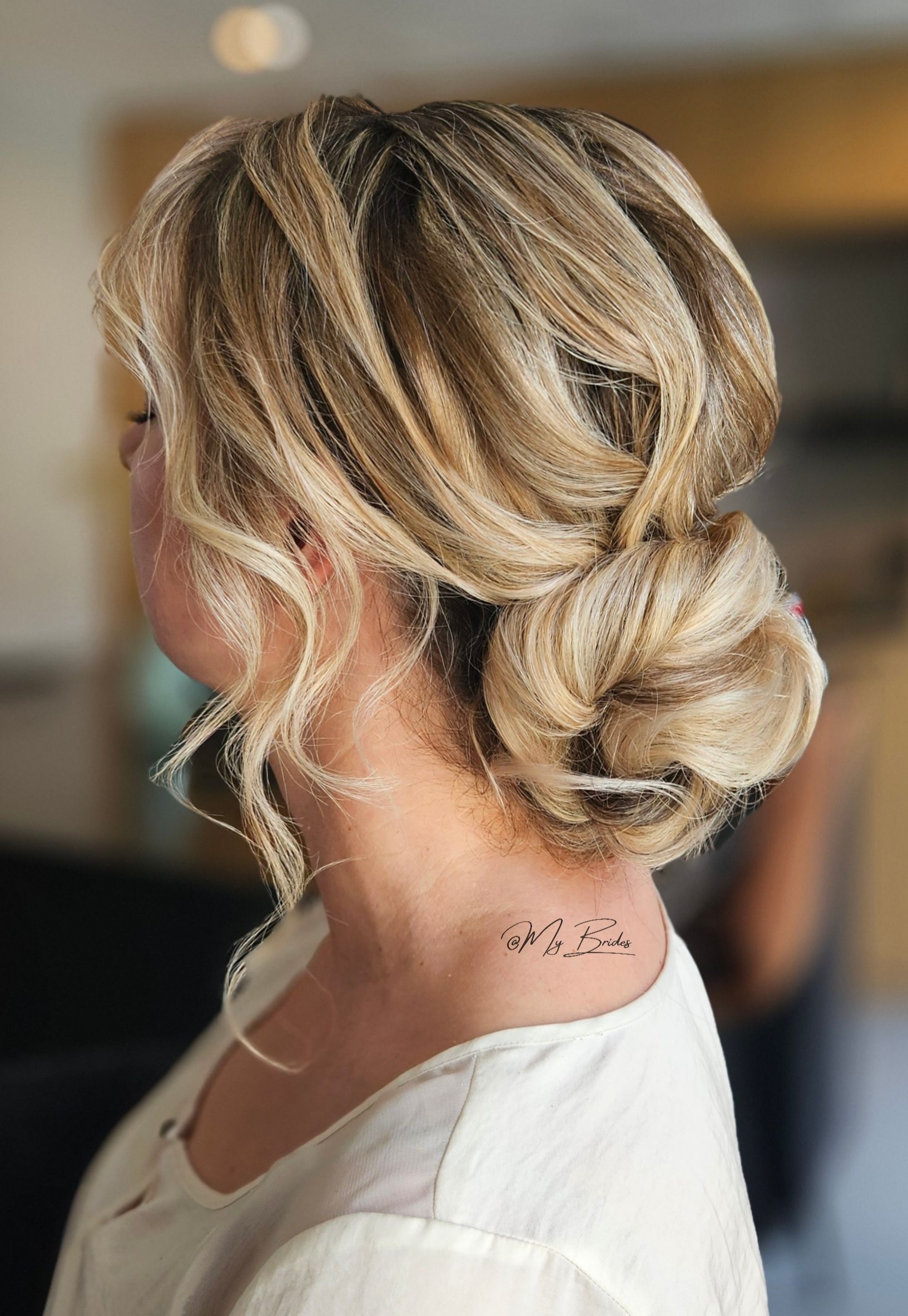 Bruidskapsel laag opgestoken in een knot, met structuur voor een moderne uitstaling
