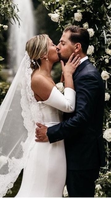 Bruid en bruidegom op trouwlocatie met witte bloemen