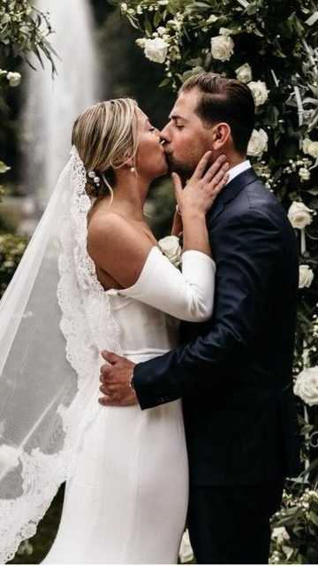 Bruid en bruidegom op trouwlocatie met witte bloemen