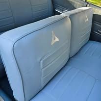 Light blue car back seat with Dodge logo.