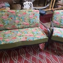 Outdoor sofa and chair with flamingo print cushions.
