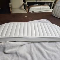 White, ribbed boat seat cushion on a brown surface, partially obscured by a white cloth.