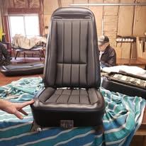 Black leather car seat, in a garage setting.