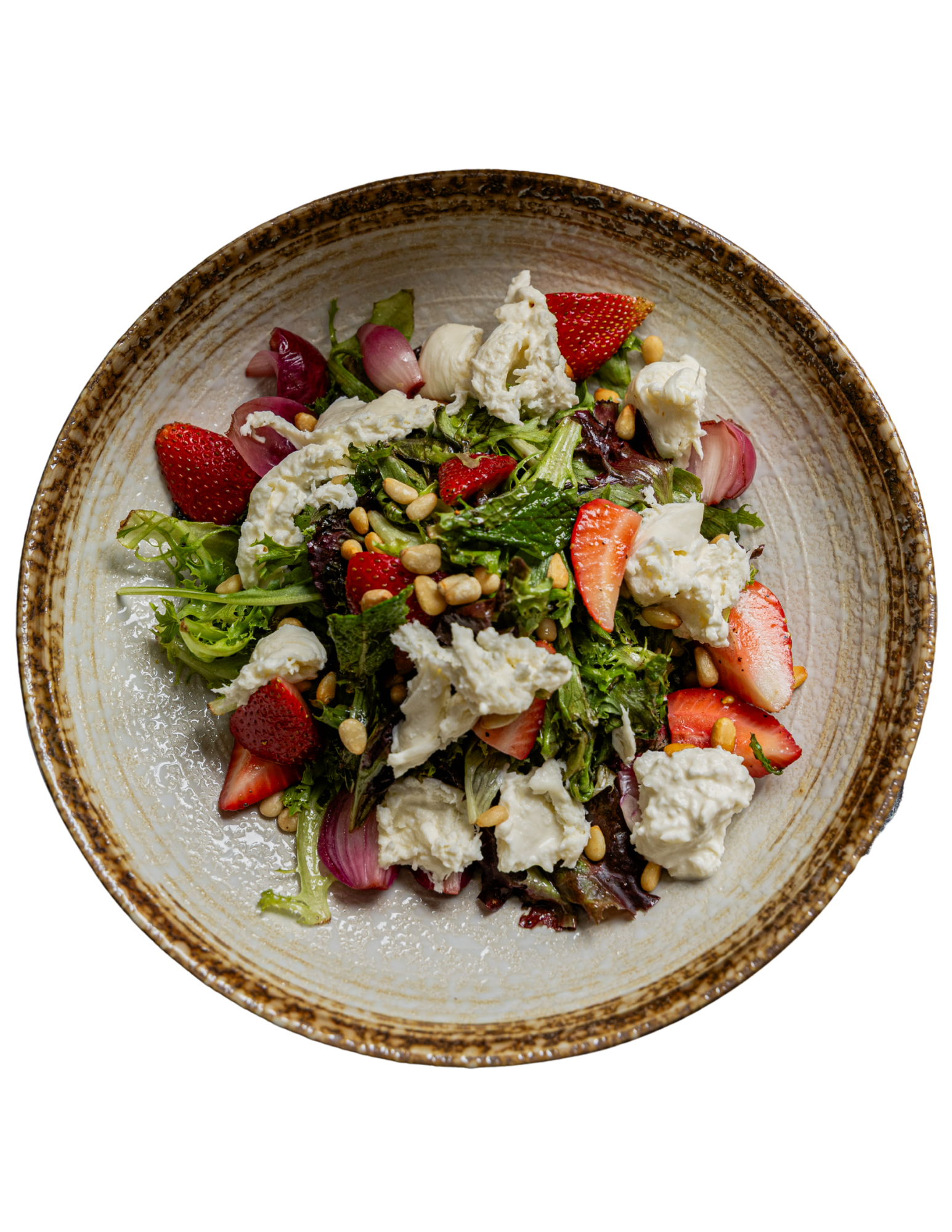 Top-down view of a salad with strawberries, greens, red onions, and crumbled cheese in a rustic bowl