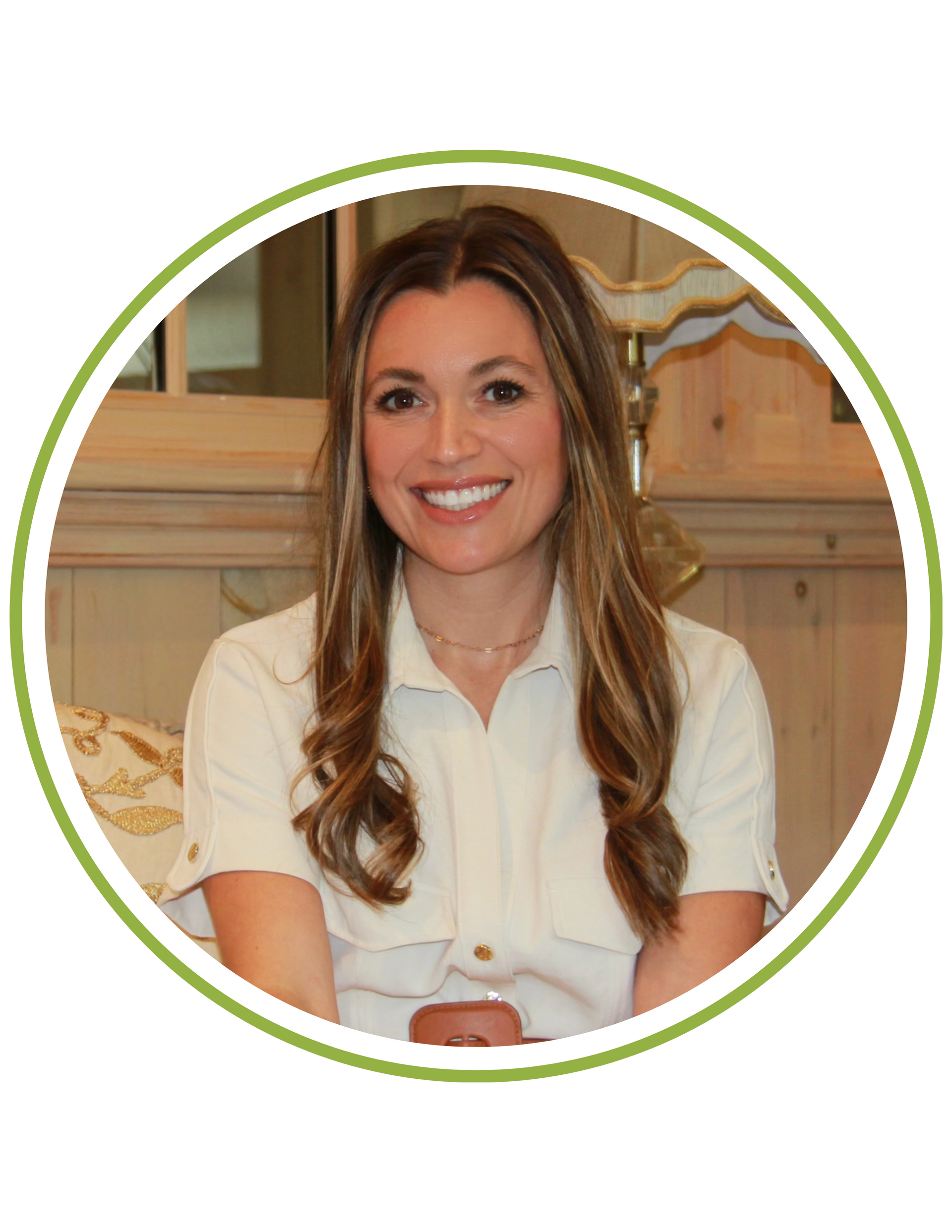 A woman wearing a lanyard around her neck smiles for the camera