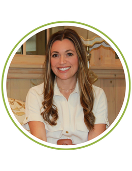 A woman wearing a lanyard around her neck is smiling.