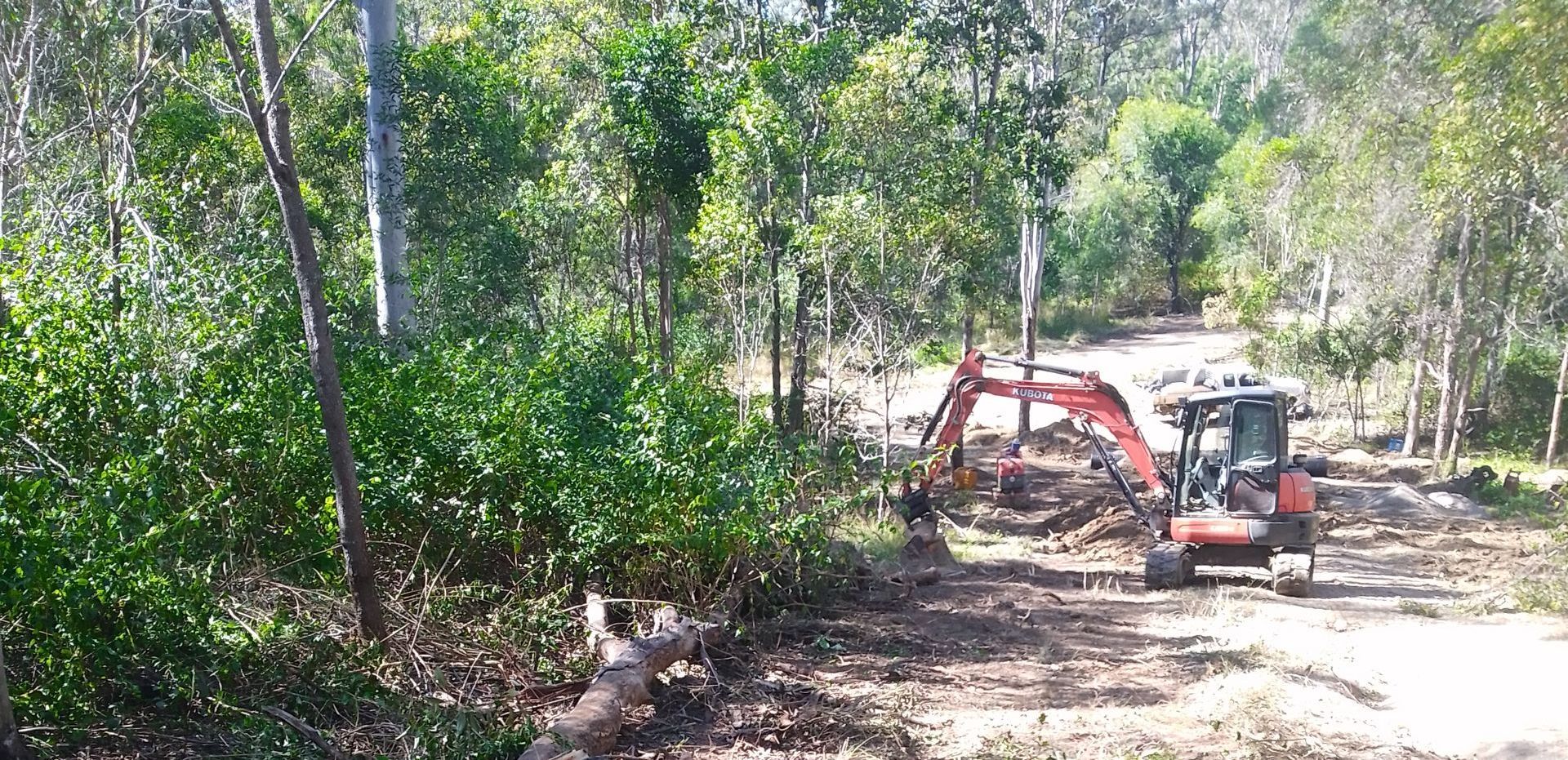 A Yellow And Black Tractor Is Parked In A Field — Ant's Earthworks In North Deep Creek, QLD 