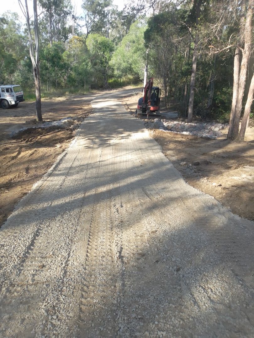 A Gravel Driveway With A Digger To The Right And Truck To The Left Of It— Ant's Earthworks In North Deep Creek, QLD