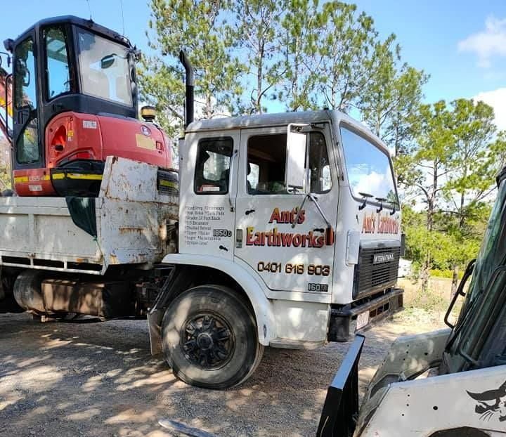 A Dump Truck Is Parked Next To A Small Excavator — Ant's Earthworks In North Deep Creek, QLD 