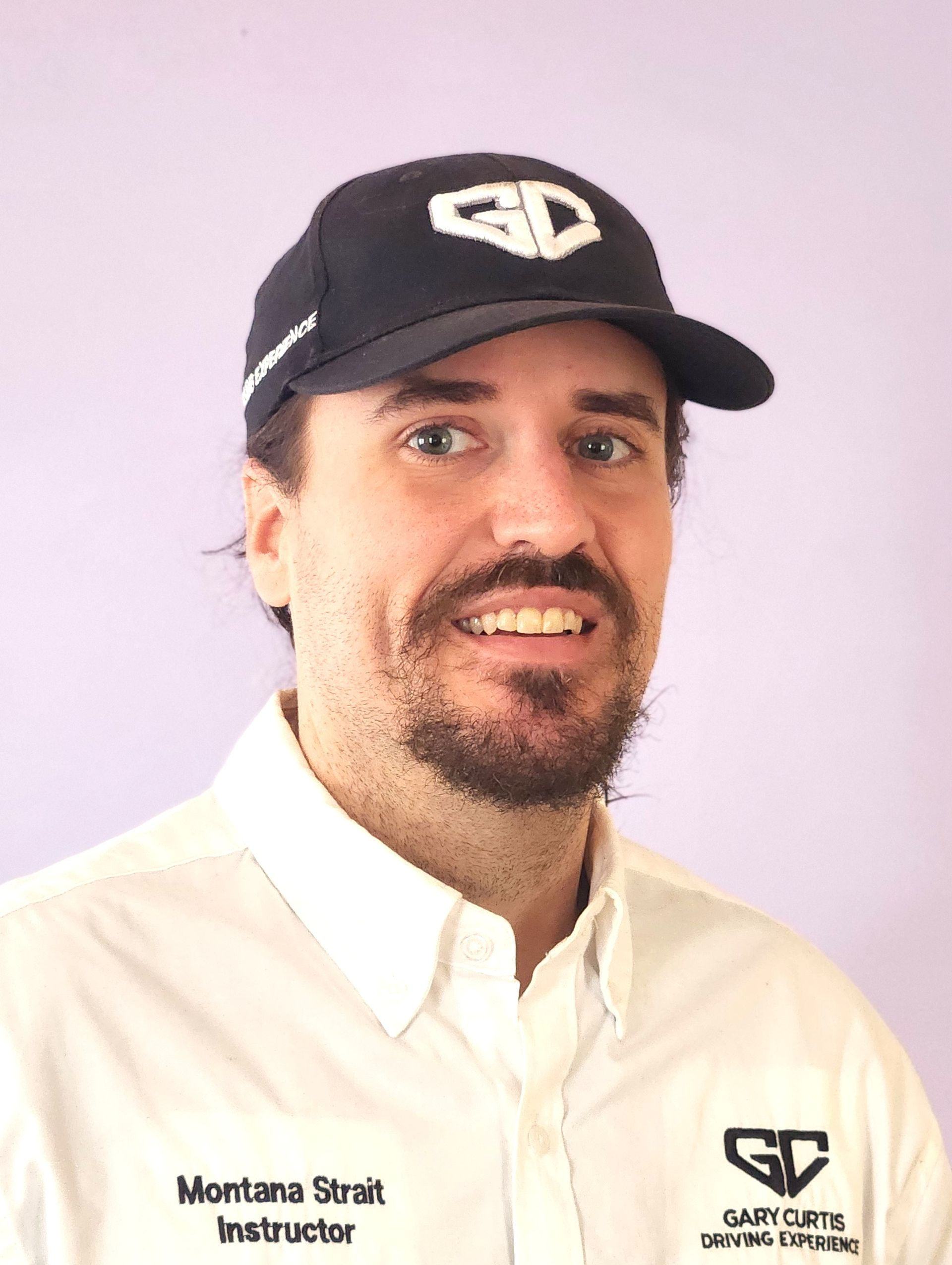 Man wearing a hat and white shirt, with a logo that says 