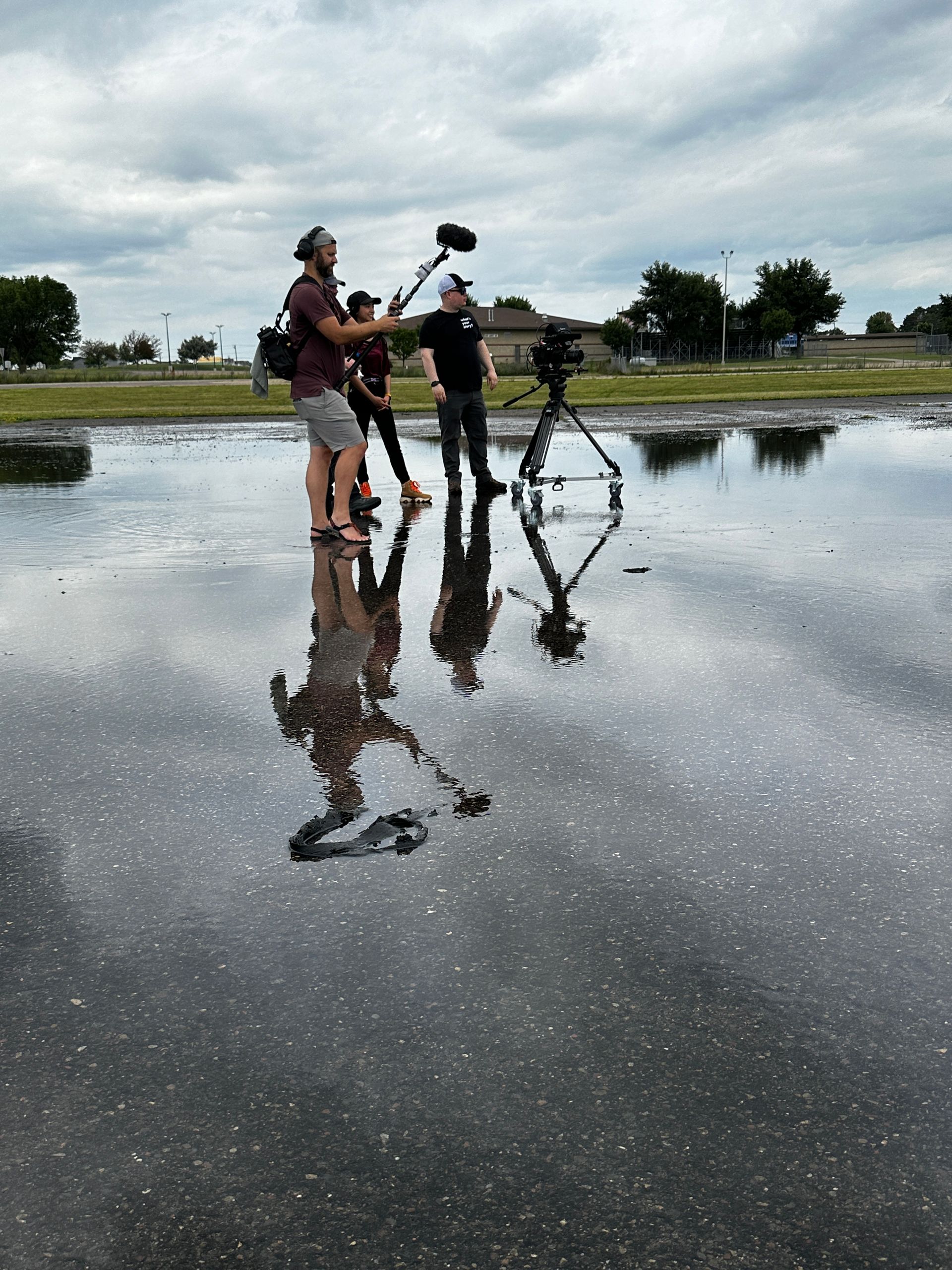 A group of people are standing in a puddle of water