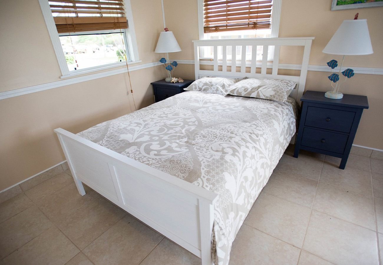 A bedroom with a white bed and two nightstands