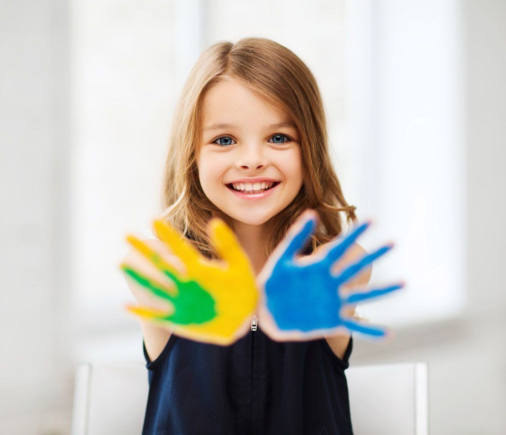 Little student girl showing painted hands — Diploma of Early Childhood Education & Care in Queensland in Kingaroy, QLD