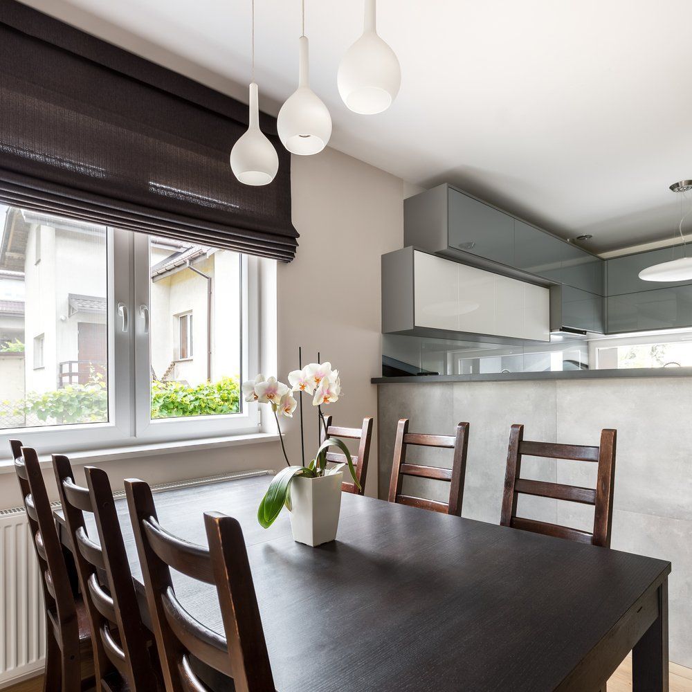 A Dining Room Table With A Vase Of Flowers On It — Peter Jones Electrical In Bonny Hills, NSW