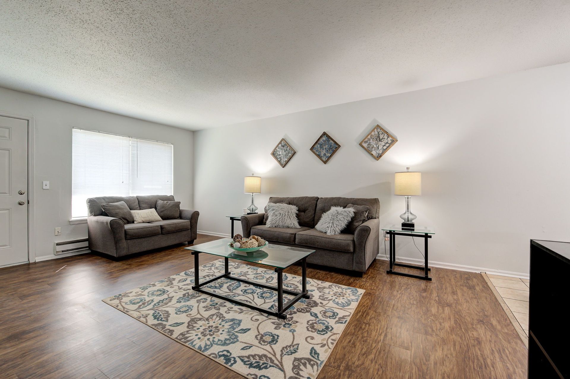 A living room with a couch , coffee table , and rug.