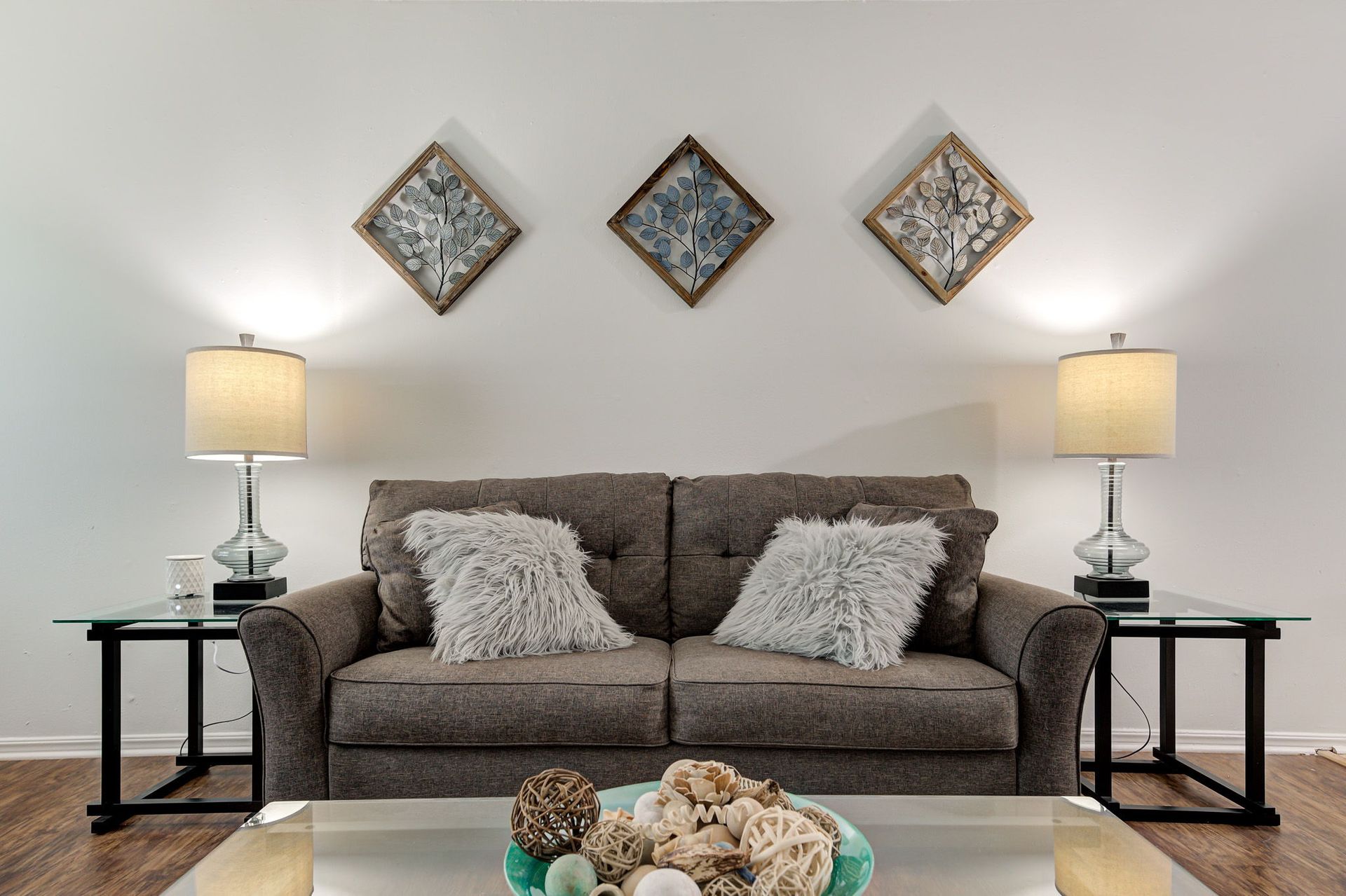 A living room with a couch , lamps , and a coffee table.