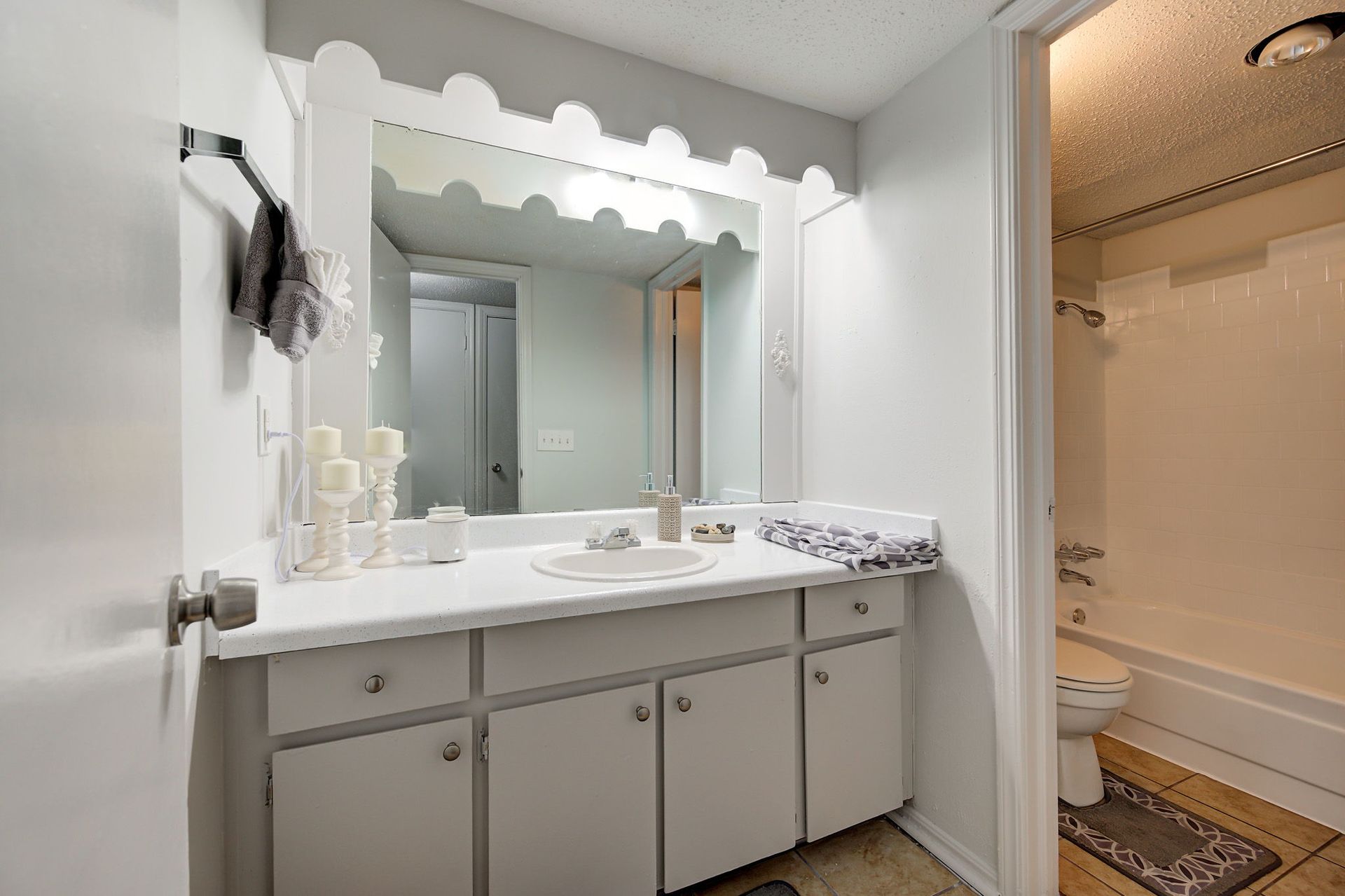 A bathroom with a sink , mirror , toilet and bathtub.
