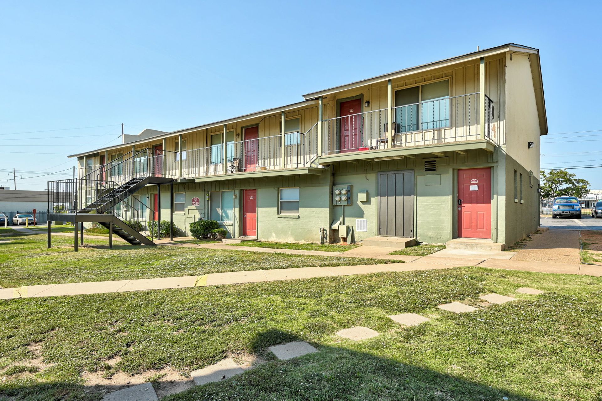 A large apartment building with stairs leading up to the second floor.