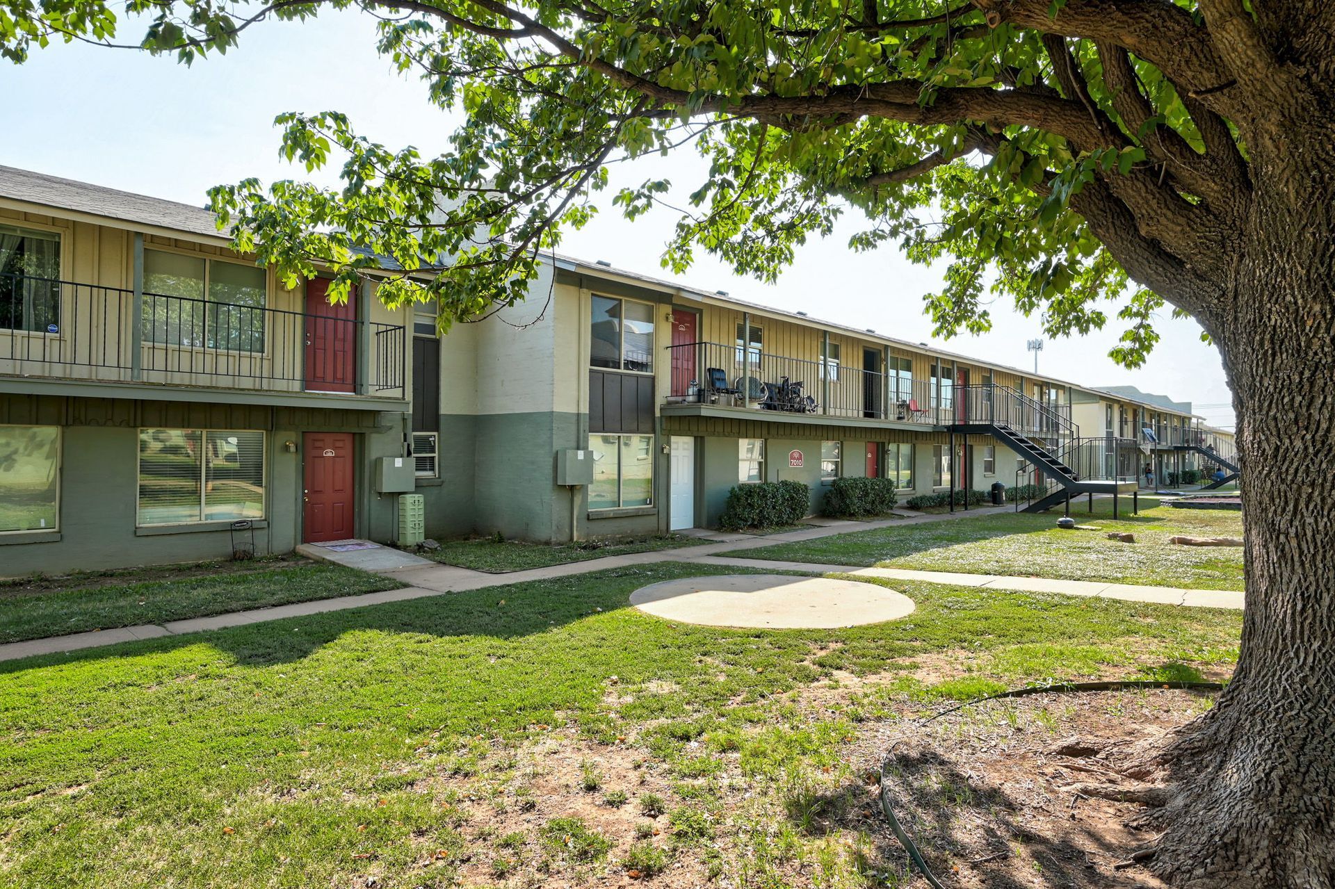 A large apartment building with a tree in front of it.