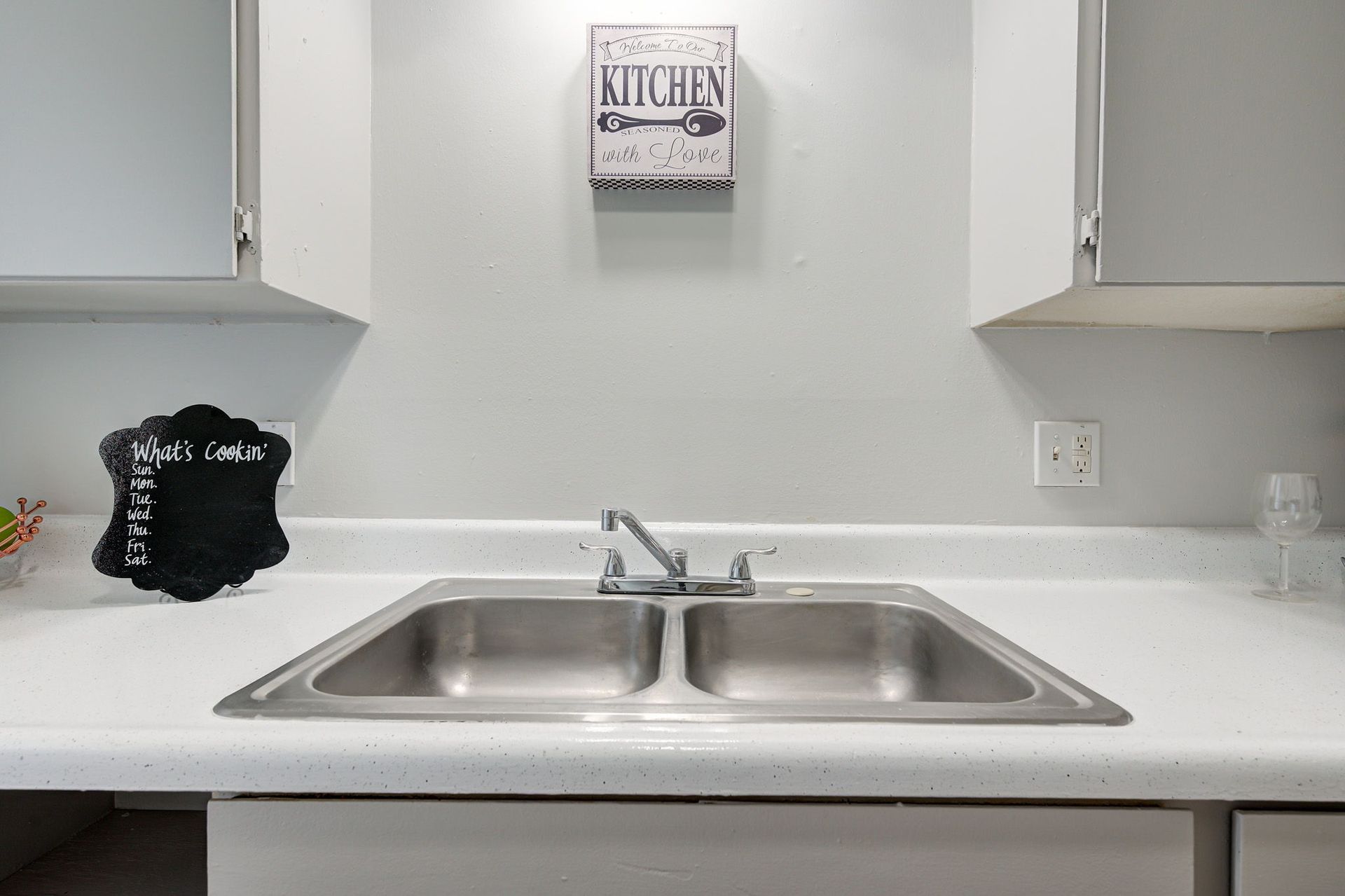 A kitchen sink with a sign above it that says kitchen.