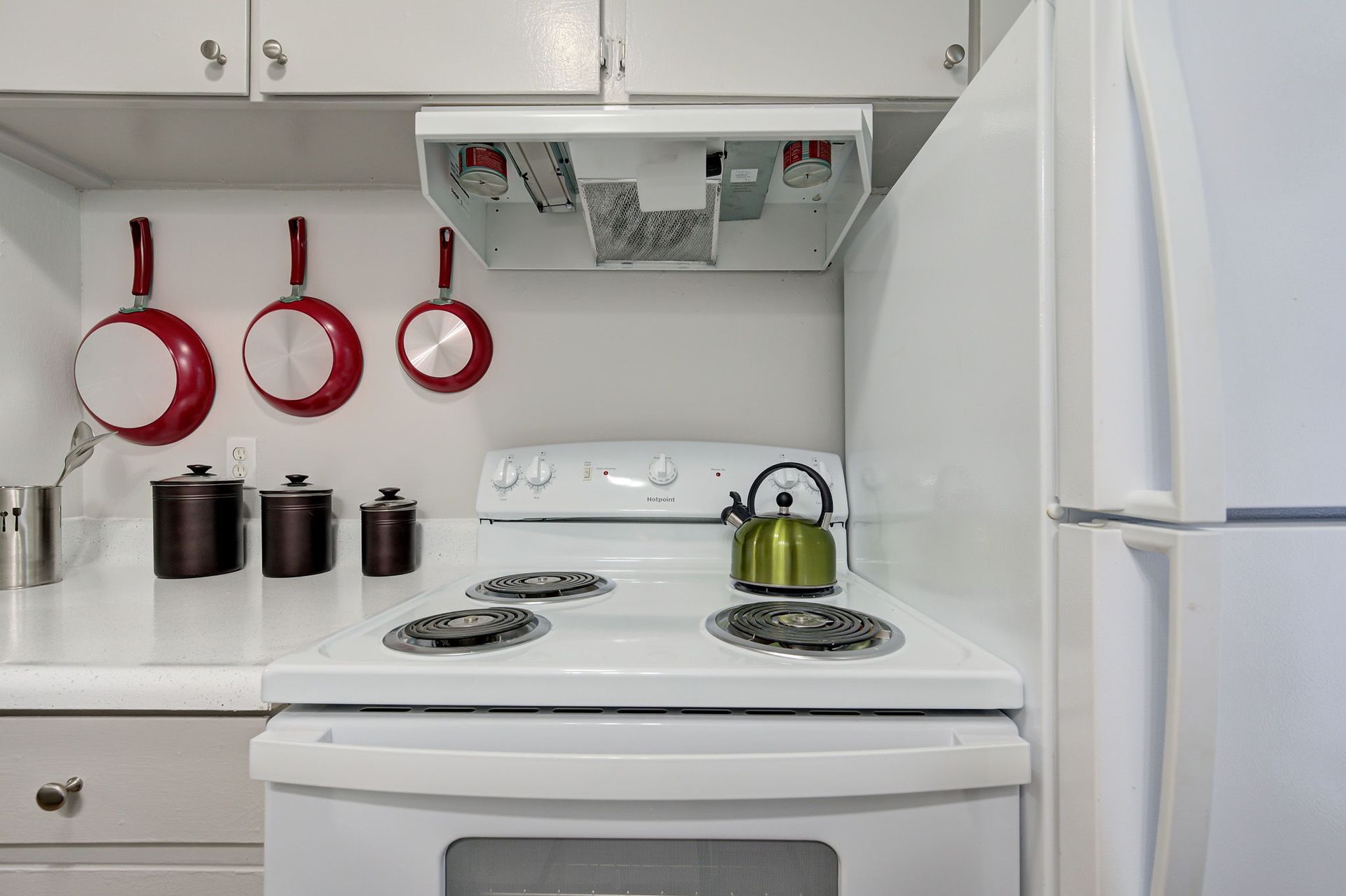 A kitchen with a white stove and a white refrigerator.