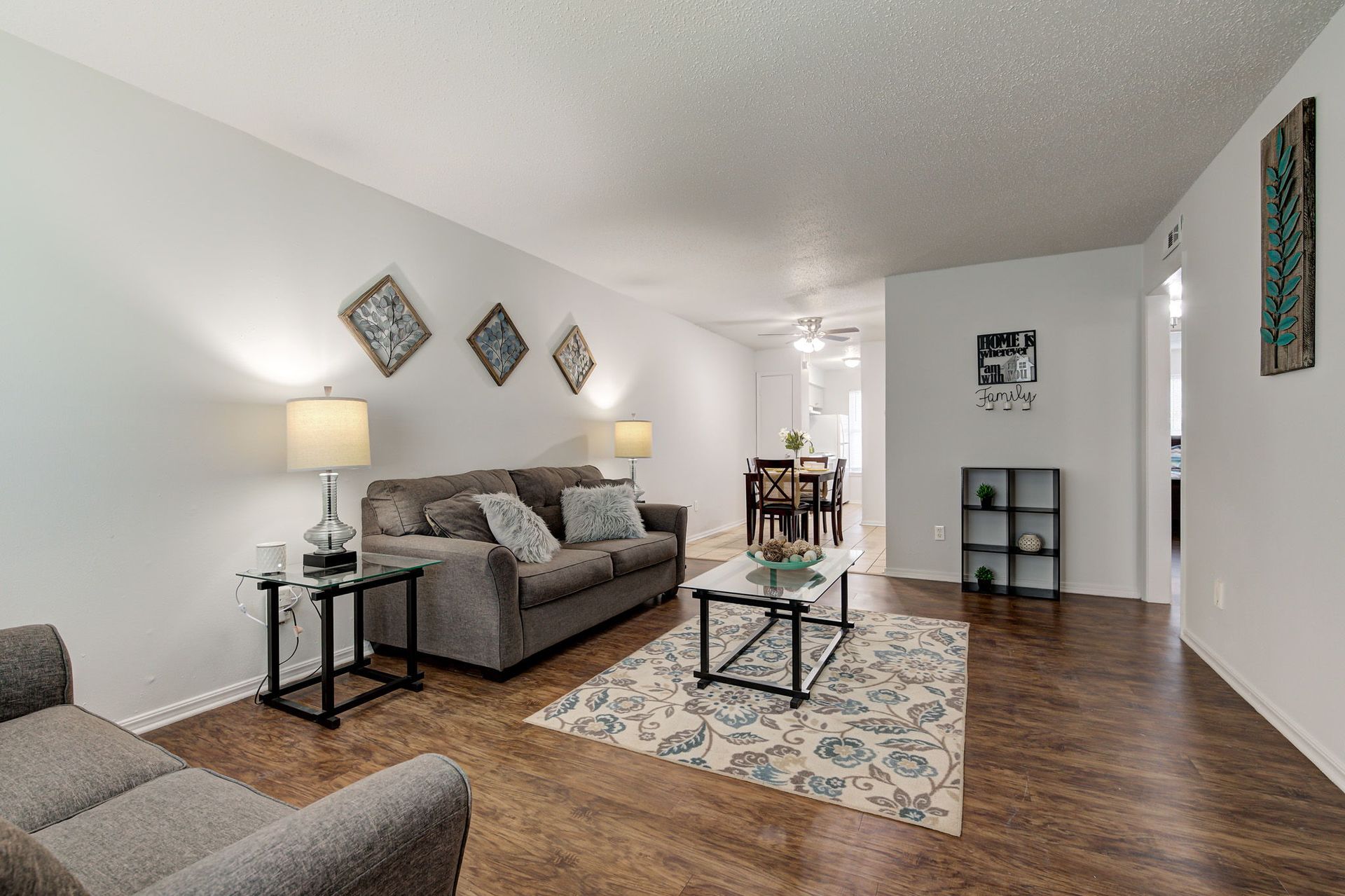A living room with a couch , chair , coffee table and rug.