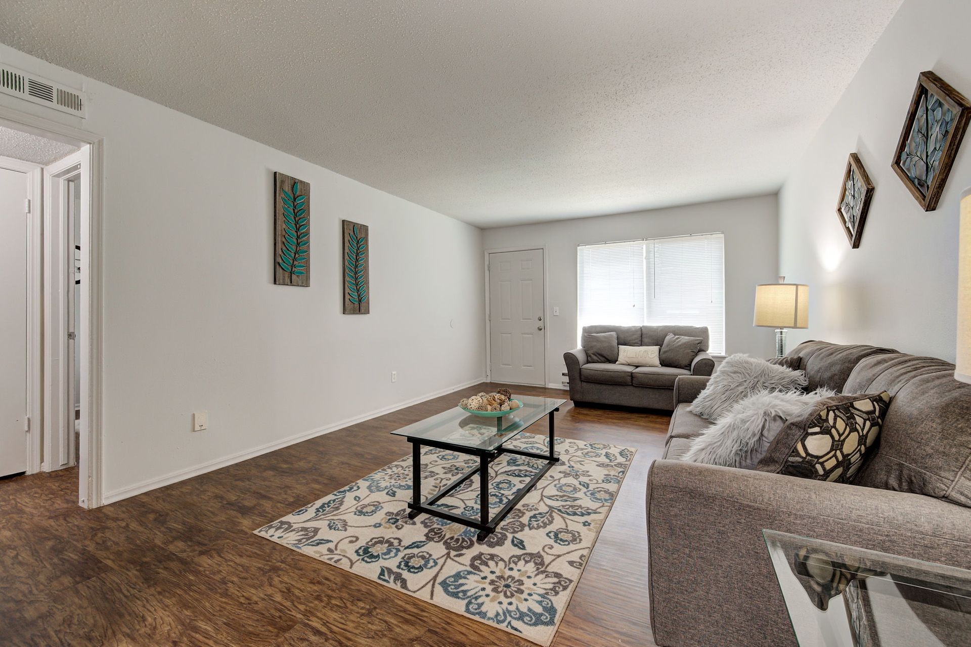A living room with a couch , coffee table , and rug.