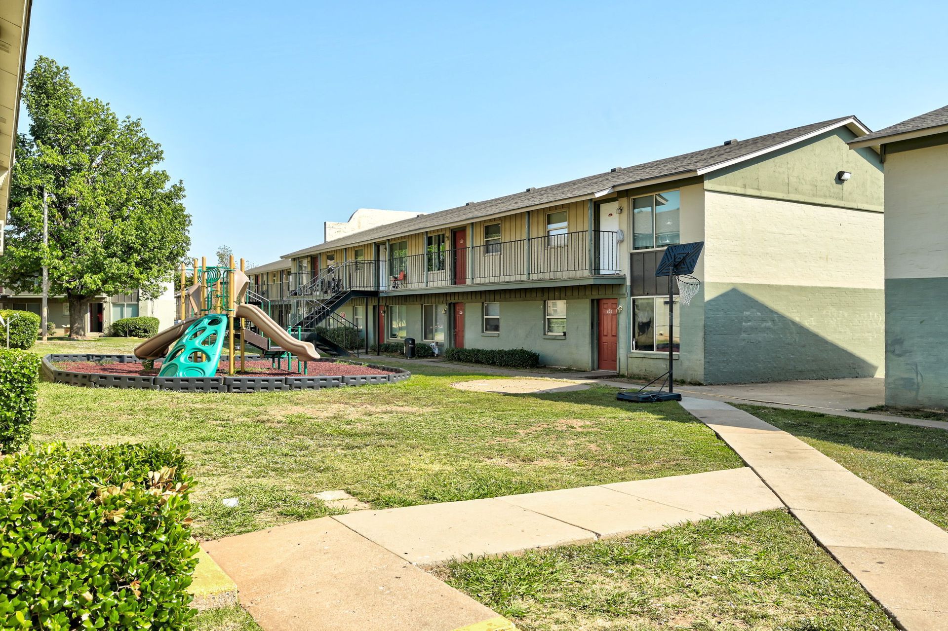 A large apartment building with a playground in front of it.