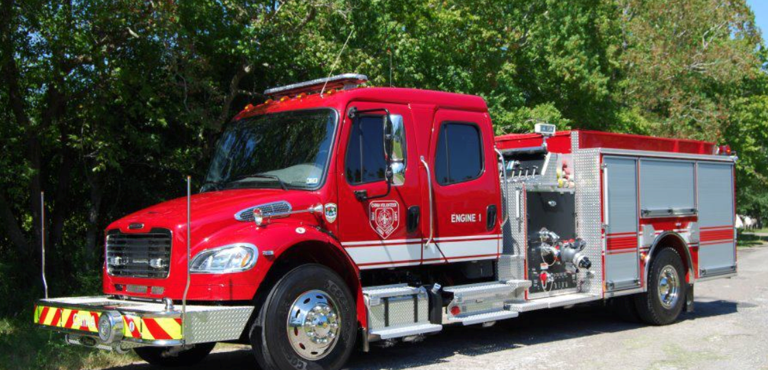 A red fire truck is parked on the side of the road.