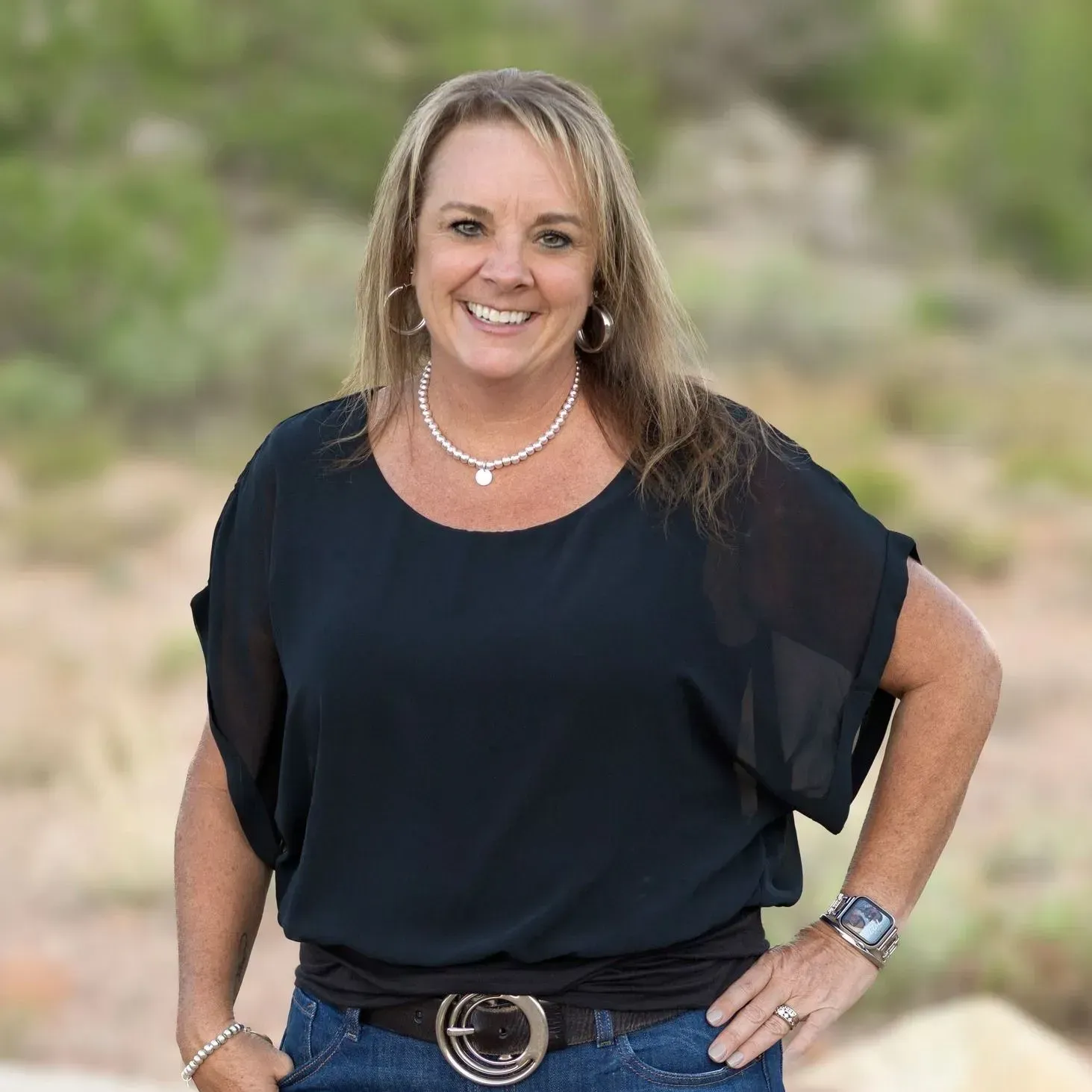 A man is holding a dog in his arms and the dog is wearing a sweater.