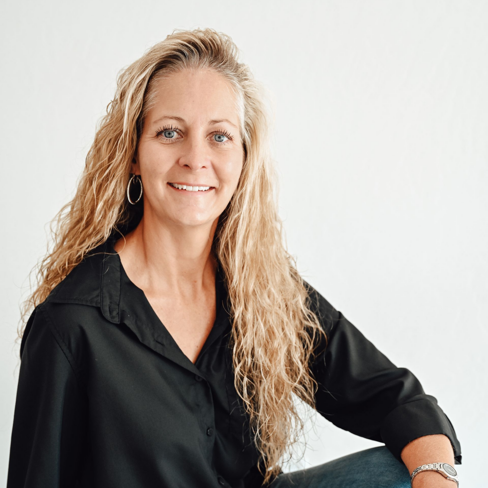 A man is holding a dog in his arms and the dog is wearing a sweater.