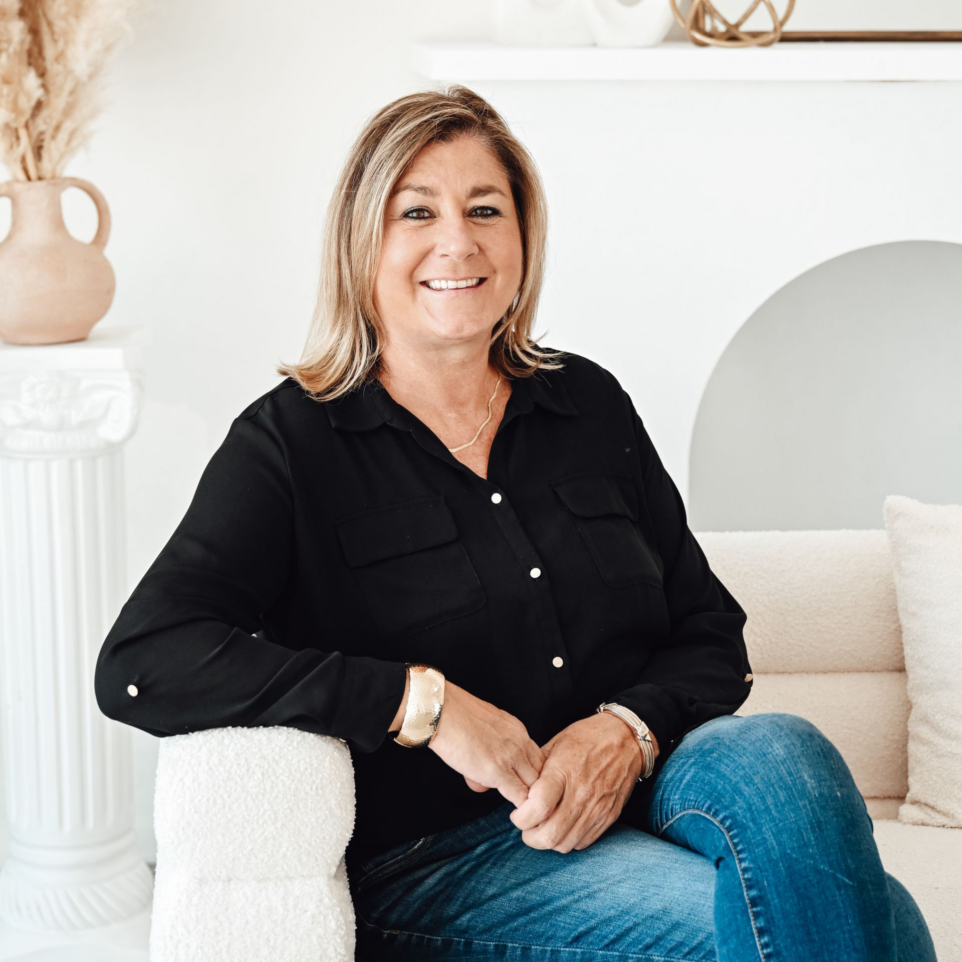 A man is holding a dog in his arms and the dog is wearing a sweater.